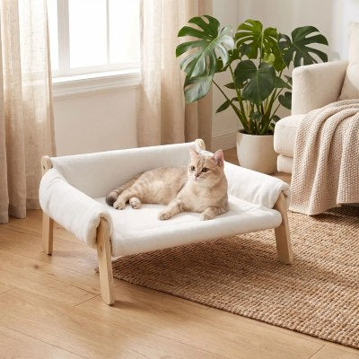 Lit pour Chat FLUFFY™ Canapé blanc avec un chat confortablement installé observant son environnement.