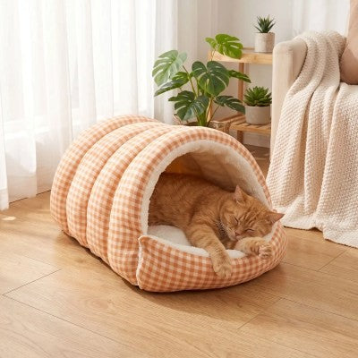 Chat roux allongé de tout son long et profondément détendu dans le lit pour chat Grotte Moelleuse, profitant d'un couchage moelleux favorisant un sommeil paisible.