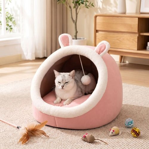 Un chat se reposant dans la niche pour chat Confort PLAYZONE™ après un moment de jeu, entouré de quelques jouets.