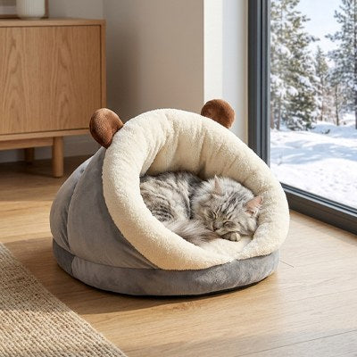 Chat gris dormant confortablement dans le Panier chat Chenille Moelleuse près d'une fenêtre avec vue sur un paysage enneigé